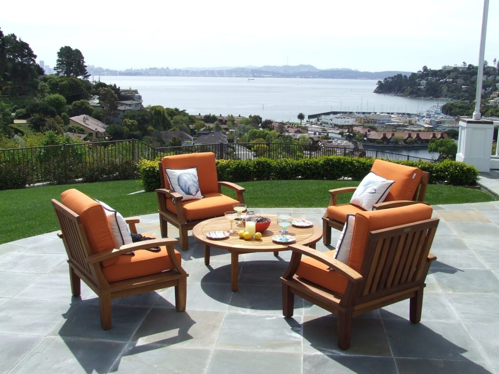 patio with with orange chairs around a table, patio, patio ideas, best patio ideas, patios 2021